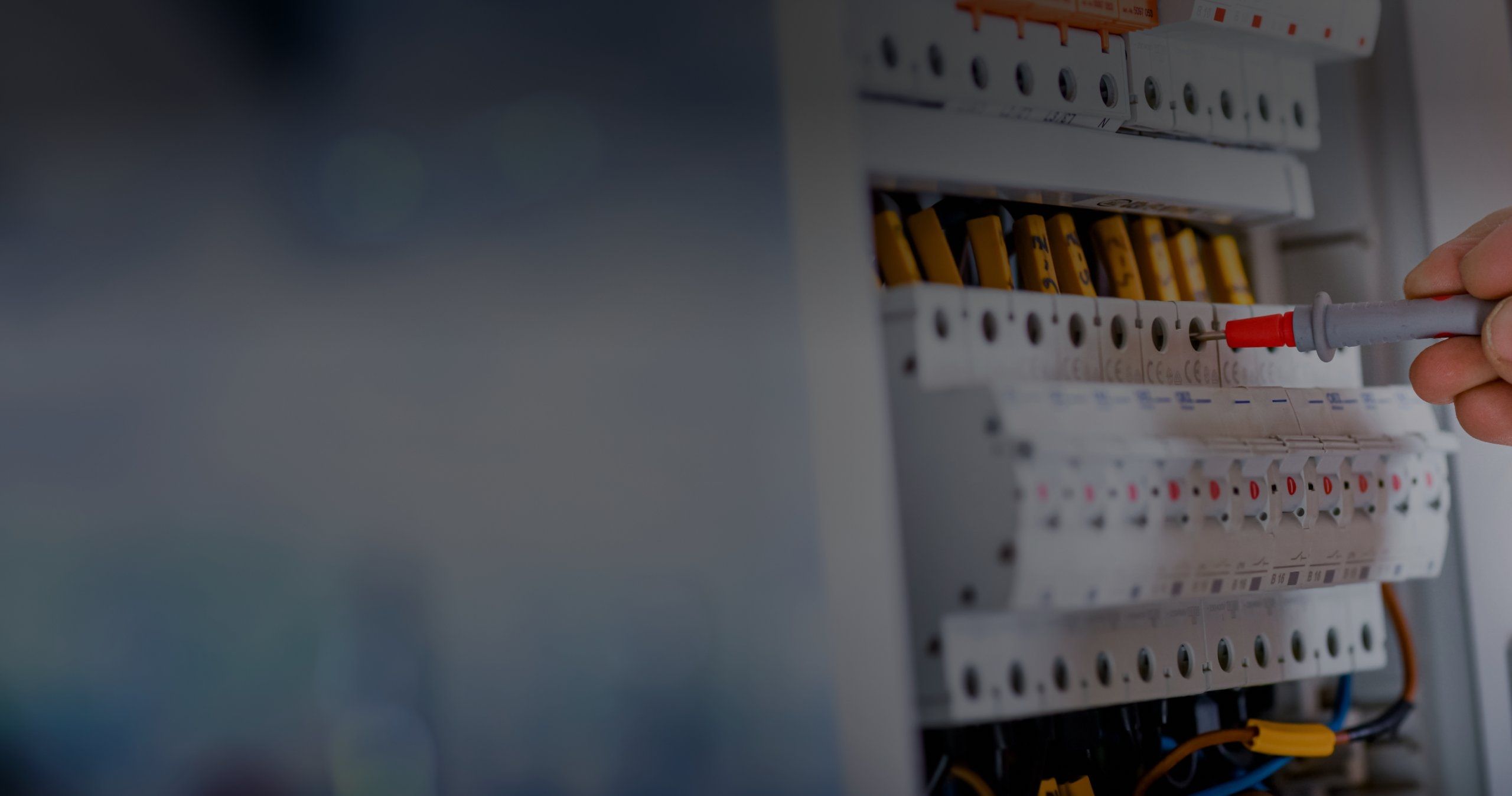 Elektriker prüft Sicherungskasten mit rotem Testgriff an Schutzschalter